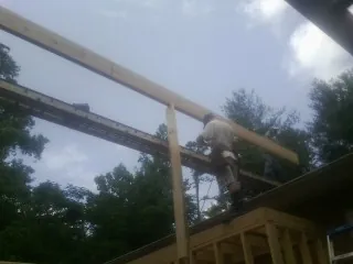 Carpenter setting a ridge beam over a new addition frame — Ice Dam Removal by Roofing Brothers in Amenia