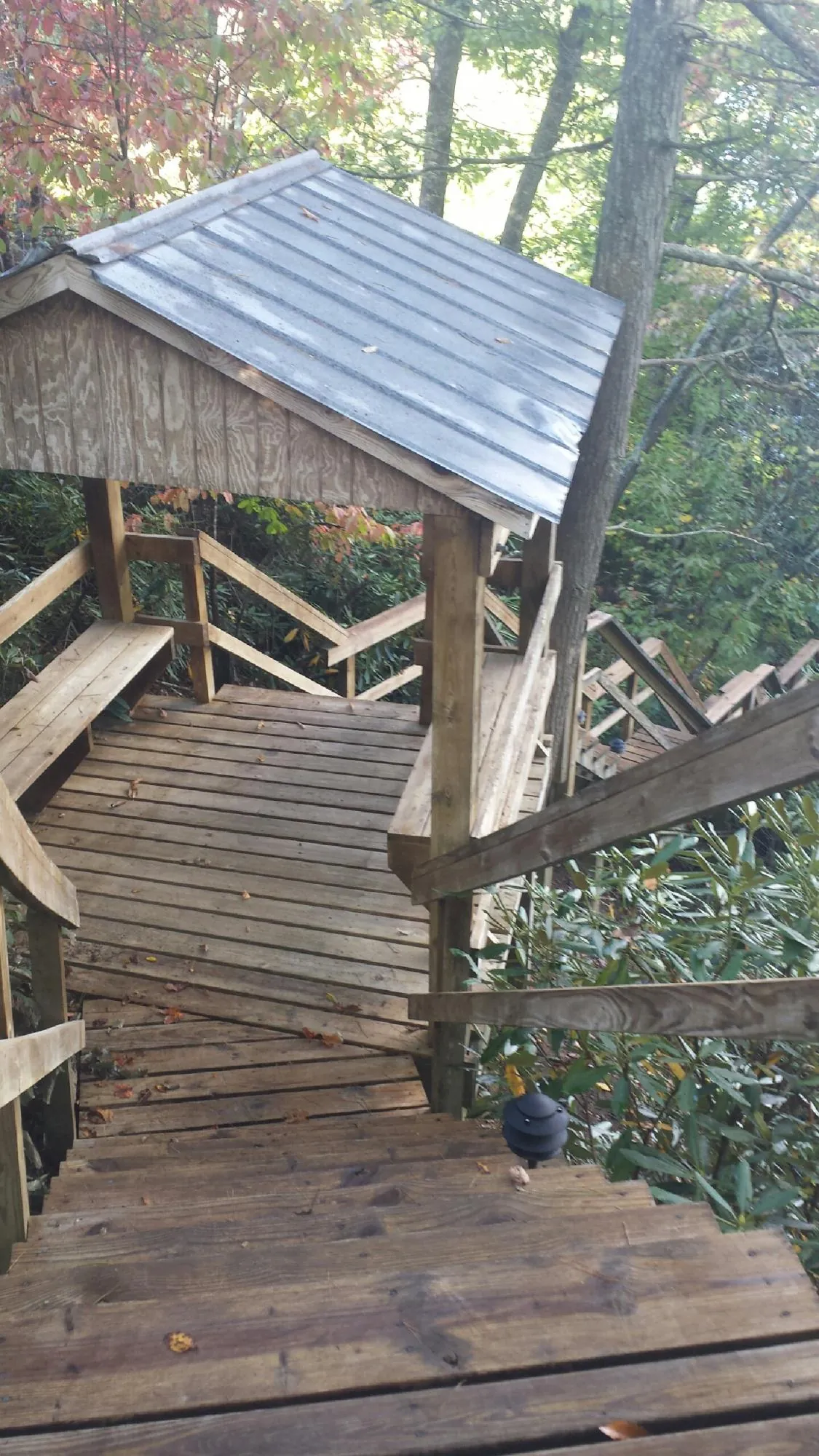 Metal roofed shelter over wooden steps on a wooded walkway — Skylight Repair & Installation work by our crew in Amenia