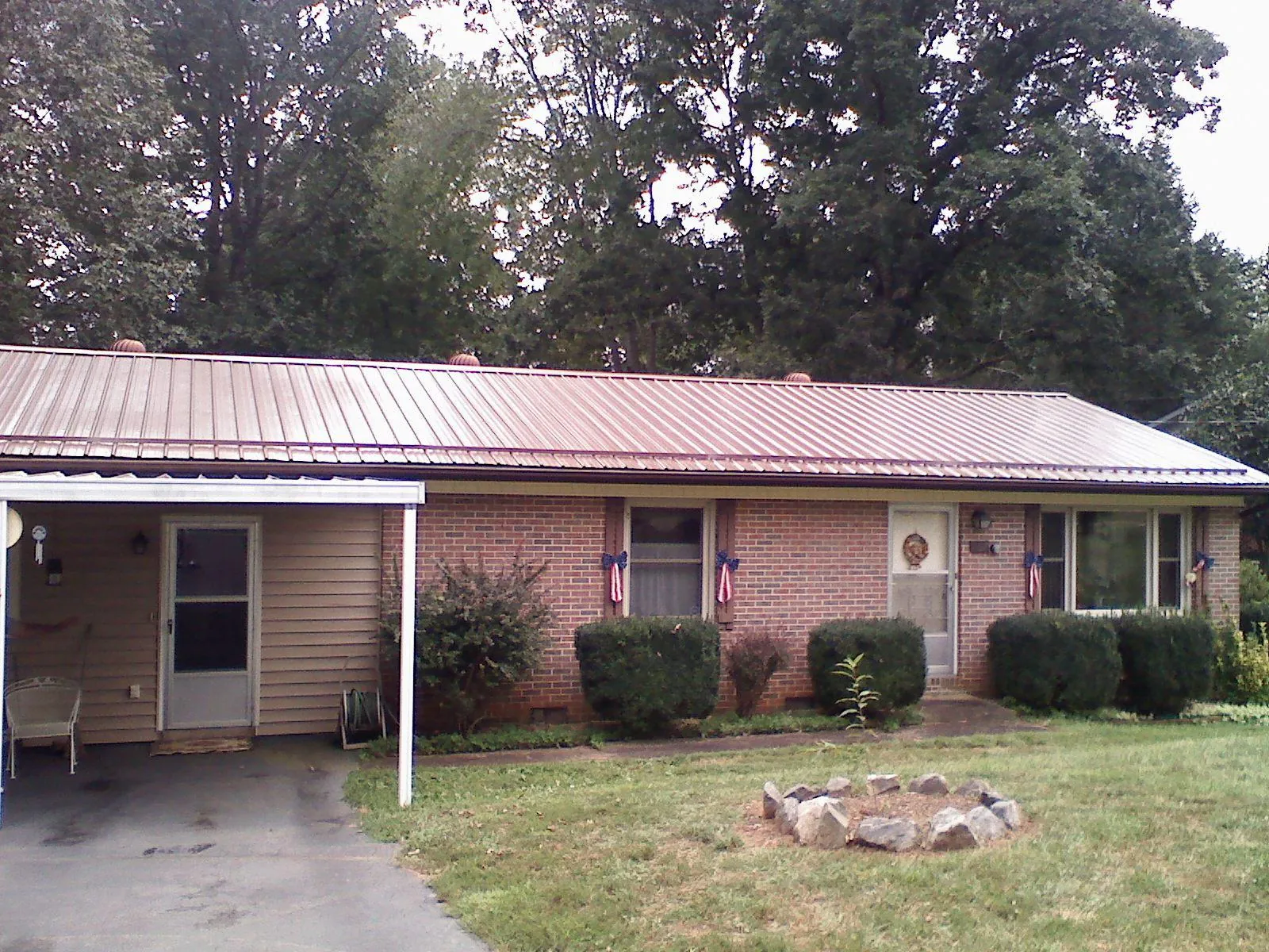 Bronze metal roof and carport on a brick ranch home — Roof Repair work by our crew in Amenia